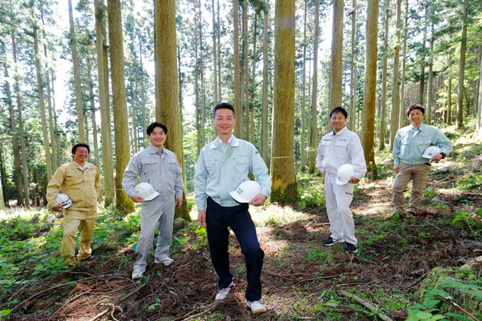 写真：木繋会　会員社の代表5人が森のなかで並んで撮影した集合写真